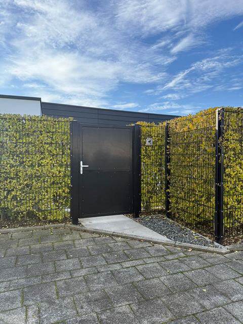Toranlage mit begr&uuml;nten Zaun in M&ouml;nchengladbach